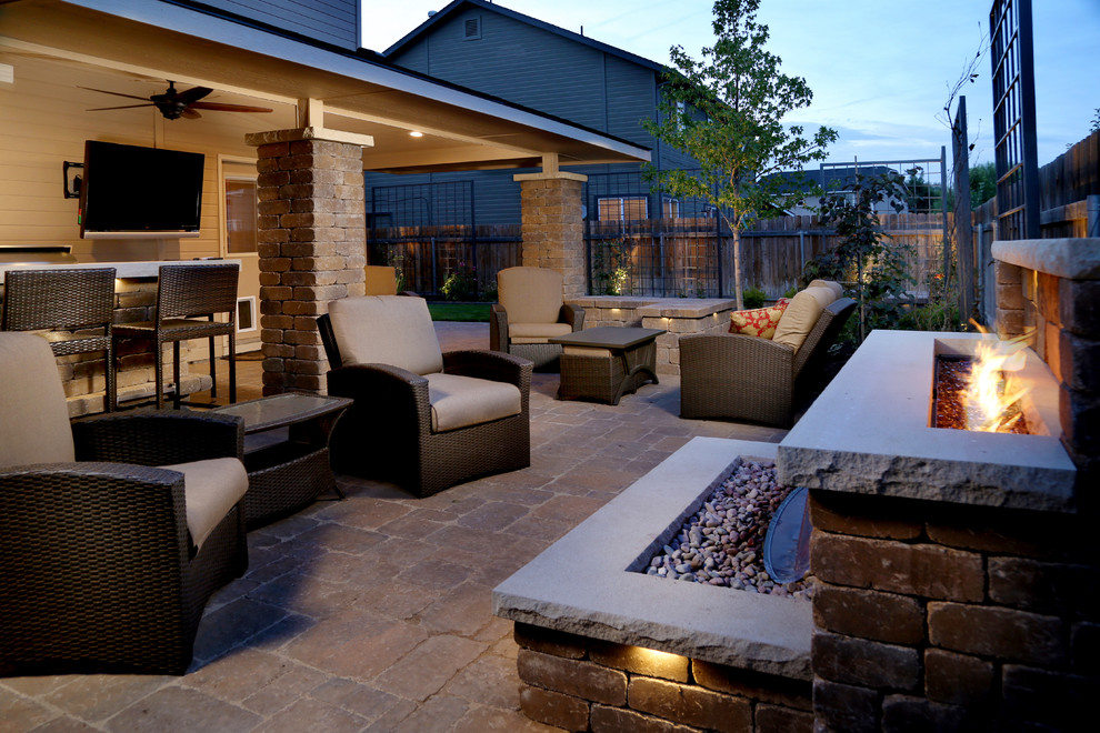 Inspiration for a mid-sized country backyard patio in Boise with a fire feature, concrete pavers and a roof extension.