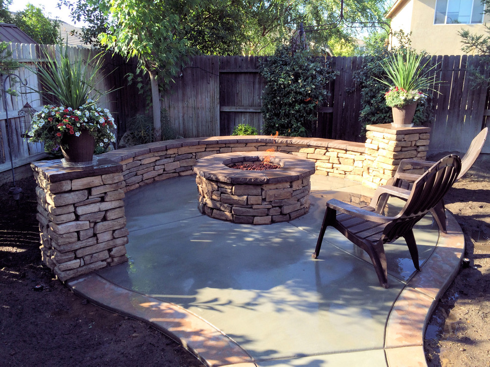 This is an example of a small arts and crafts backyard patio in Other with a fire feature and stamped concrete.