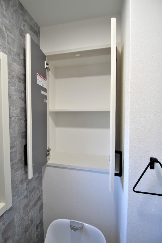 Photo of a traditional gender-neutral storage and wardrobe in Other with flat-panel cabinets, light wood cabinets, white floor and wood.