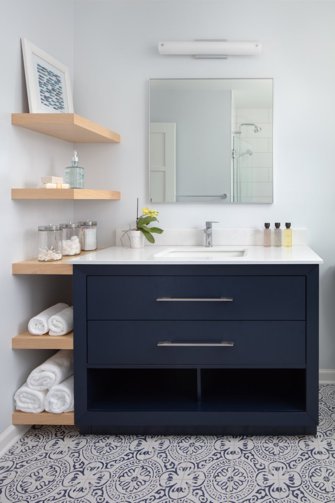 Mid-sized trendy kids' white tile and porcelain tile porcelain tile, multicolored floor and single-sink alcove shower photo in Other with flat-panel cabinets, blue cabinets, a two-piece toilet, blue walls, an undermount sink, quartz countertops, a hinged shower door, white countertops, a niche and a freestanding vanity
