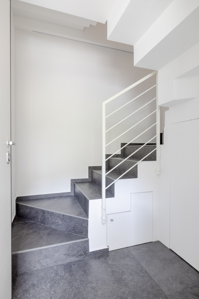 Idee per un piccolo ingresso contemporaneo con pareti bianche, pavimento in gres porcellanato, una porta singola, una porta bianca, pavimento nero, travi a vista e armadio
