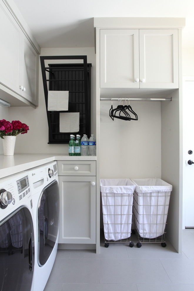 Photo of a traditional l-shaped laundry room in Los Angeles with grey cabinets, recessed-panel cabinets, a side-by-side washer and dryer and white benchtop.