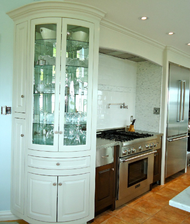 This is an example of a mid-sized transitional u-shaped eat-in kitchen in Vancouver with a farmhouse sink, beaded inset cabinets, white cabinets, marble benchtops, white splashback, stone tile splashback, stainless steel appliances, ceramic floors and with island.