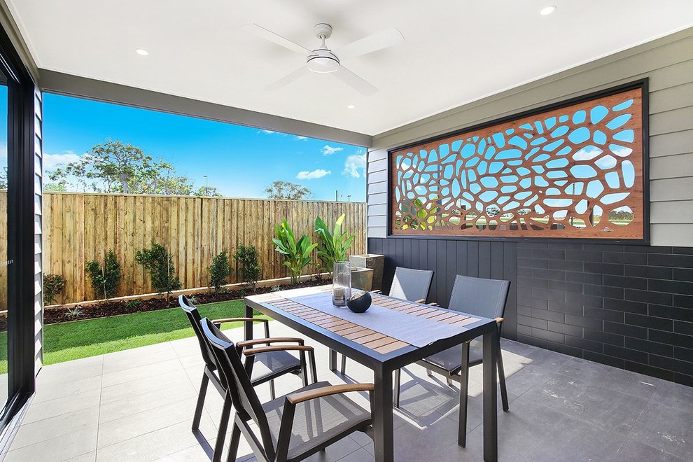 Photo of a contemporary backyard patio in Brisbane with concrete pavers and a roof extension.