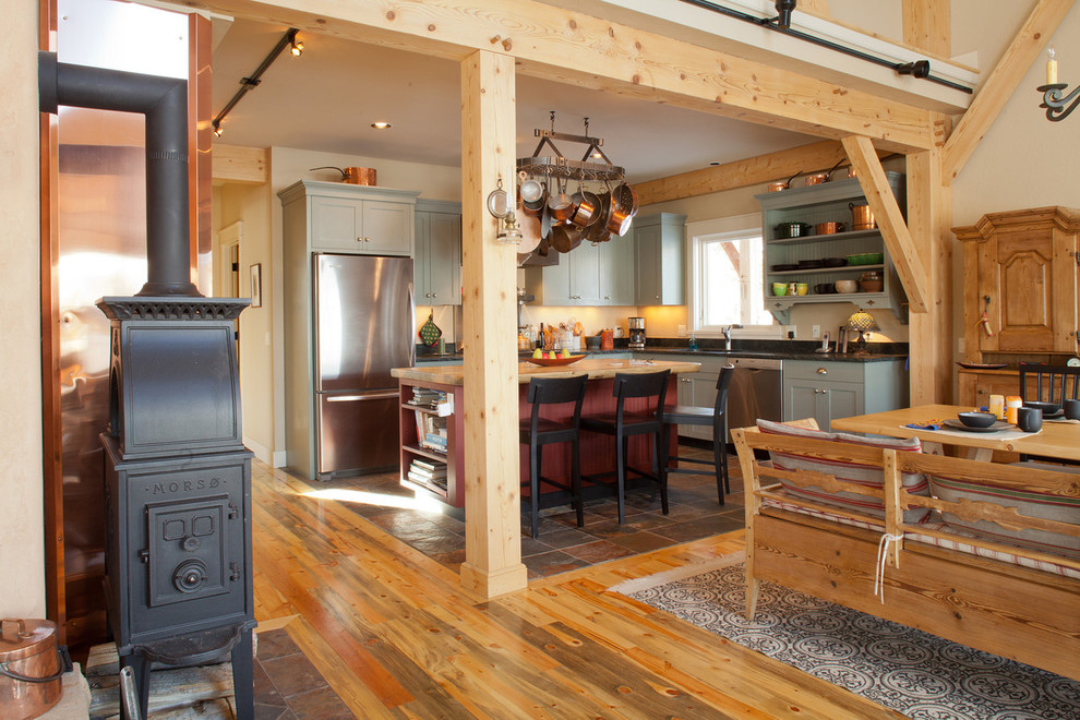Eat-in kitchen - mid-sized rustic l-shaped slate floor and multicolored floor eat-in kitchen idea in Denver with open cabinets, green cabinets, quartzite countertops, black backsplash, stone slab backsplash, stainless steel appliances and an island