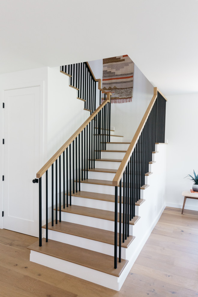 Large country wood u-shaped staircase in Los Angeles with wood risers and mixed railing.