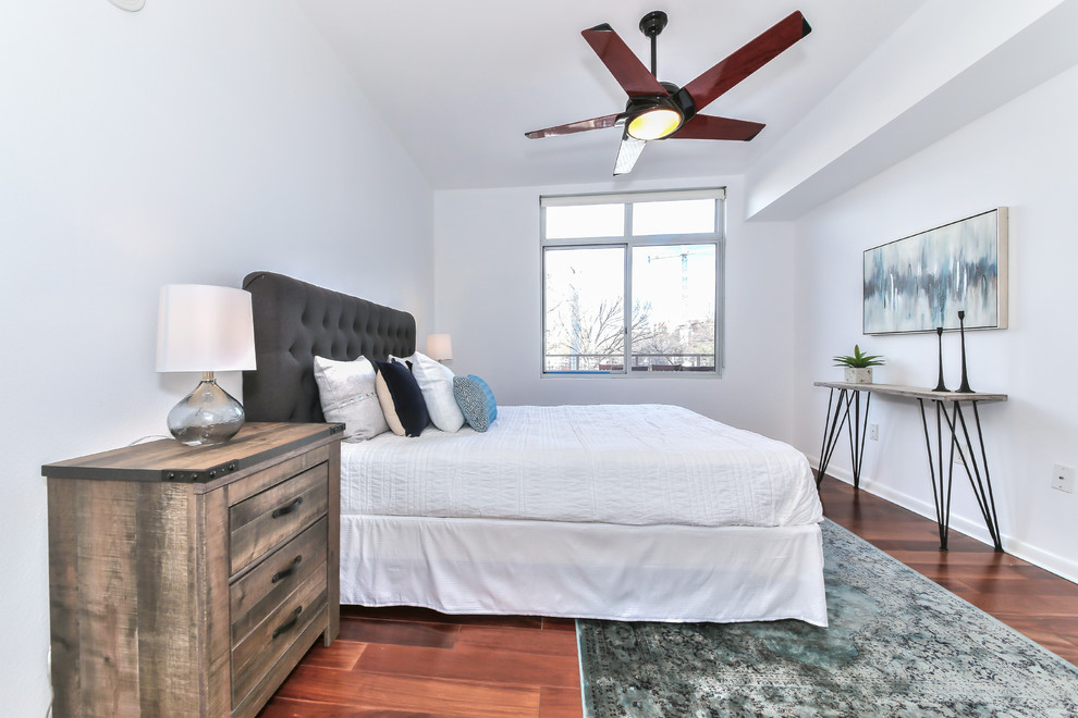 Inspiration for a modern master bedroom in Austin with white walls and medium hardwood floors.