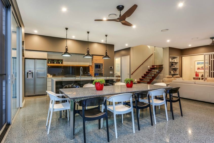 Photo of a mid-sized modern open plan dining in Brisbane with grey walls, concrete floors and a tile fireplace surround.