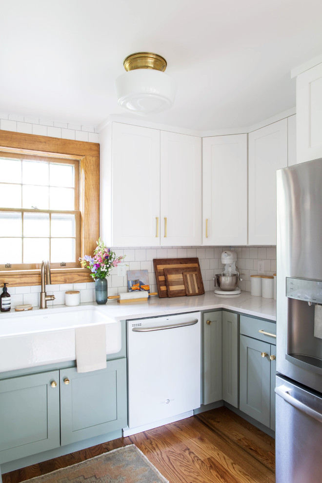 Small transitional l-shaped eat-in kitchen in Other with a farmhouse sink, recessed-panel cabinets, grey cabinets, white splashback, subway tile splashback, white appliances, dark hardwood floors, brown floor and quartz benchtops.