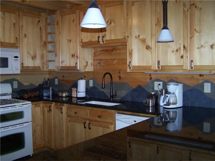 Mid-sized mountain style u-shaped porcelain tile open concept kitchen photo in Chicago with an undermount sink, shaker cabinets, light wood cabinets, granite countertops, gray backsplash, porcelain backsplash, white appliances and a peninsula