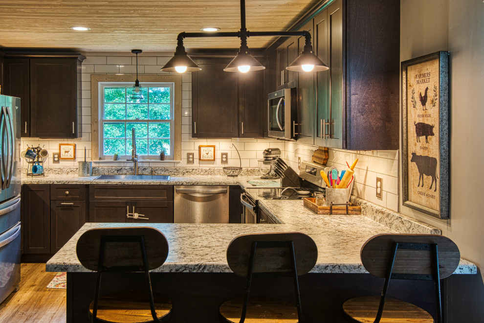 Inspiration for a mid-sized transitional u-shaped light wood floor and brown floor open concept kitchen remodel with a drop-in sink, shaker cabinets, gray cabinets, laminate countertops, white backsplash, subway tile backsplash, stainless steel appliances, a peninsula and white countertops