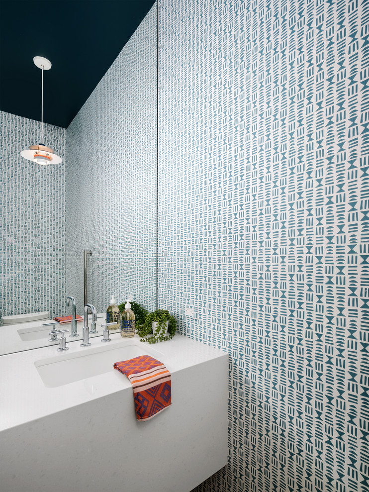 Photo of a contemporary powder room in Austin with multi-coloured walls, an undermount sink and white benchtops.