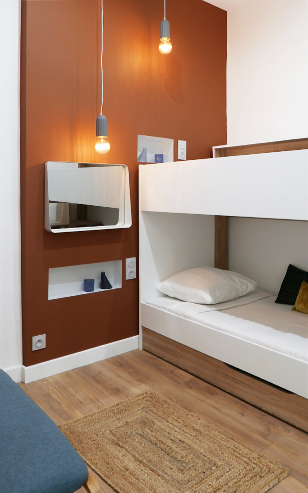 Idéer för mellanstora funkis barnrum kombinerat med sovrum, med orange väggar och laminatgolv