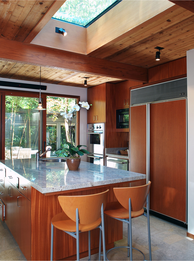 This is an example of an asian kitchen in San Francisco with panelled appliances, flat-panel cabinets and medium wood cabinets.