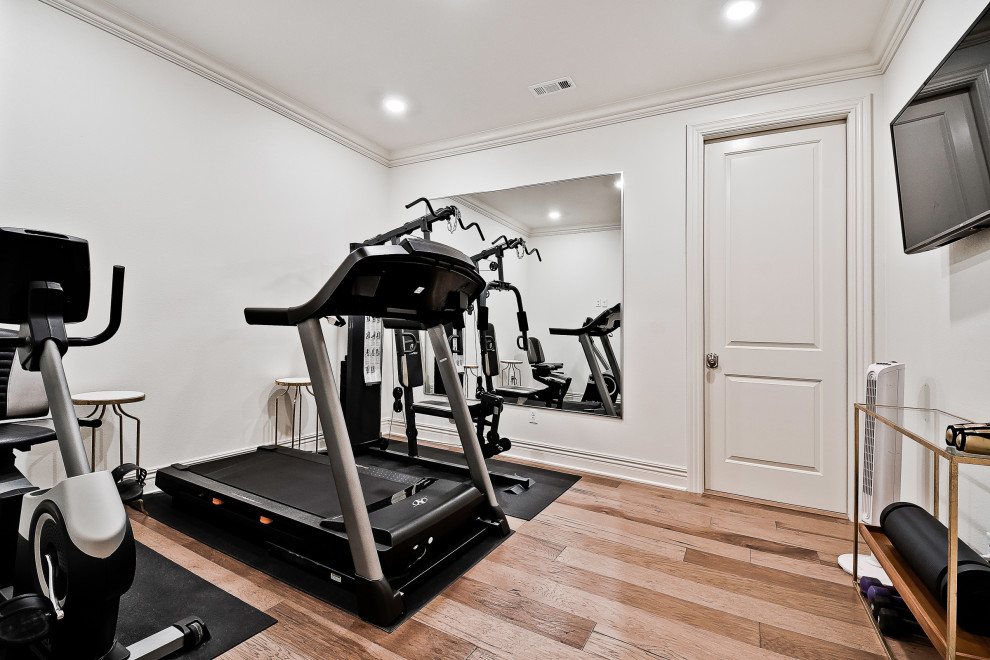 Small transitional multipurpose gym in Other with white walls and light hardwood floors.