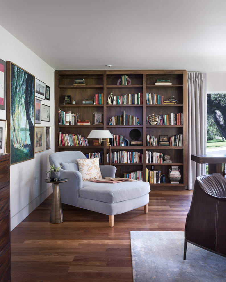 Photo of a large contemporary living room in Austin with a library, white walls, dark hardwood floors, a standard fireplace and a brick fireplace surround.