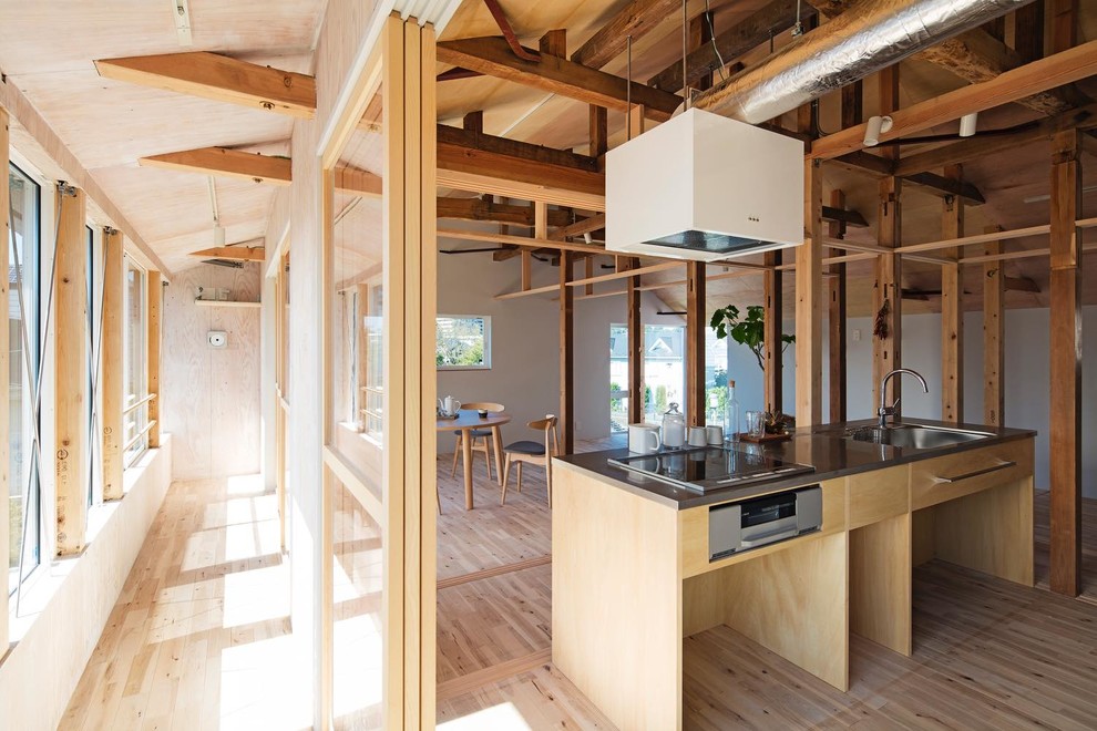 Photo of a mid-sized asian single-wall open plan kitchen in Tokyo Suburbs with an integrated sink, open cabinets, stainless steel benchtops, stainless steel appliances, light hardwood floors, with island and beige floor.