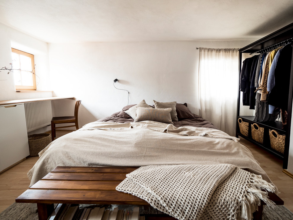Стильный дизайн: хозяйская спальня среднего размера в стиле фьюжн с белыми стенами, полом из ламината, коричневым полом и обоями на стенах - последний тренд