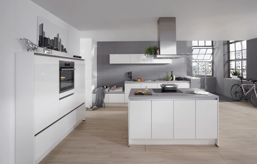 Inspiration for an expansive industrial l-shaped open plan kitchen in Essen with an undermount sink, flat-panel cabinets, white cabinets, concrete benchtops, grey splashback, metal splashback, stainless steel appliances, ceramic floors and multiple islands.