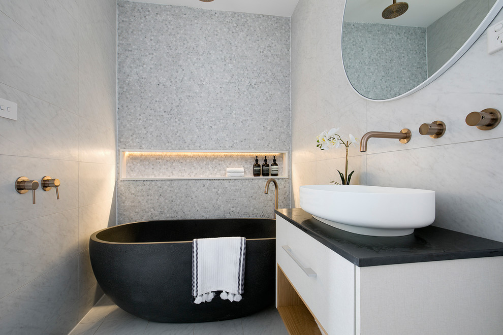 Inspiration for a contemporary bathroom in Sydney with flat-panel cabinets, white cabinets, a freestanding tub, an open shower, gray tile, ceramic tile, grey walls, ceramic floors, a vessel sink, engineered quartz benchtops, black benchtops, grey floor and an open shower.