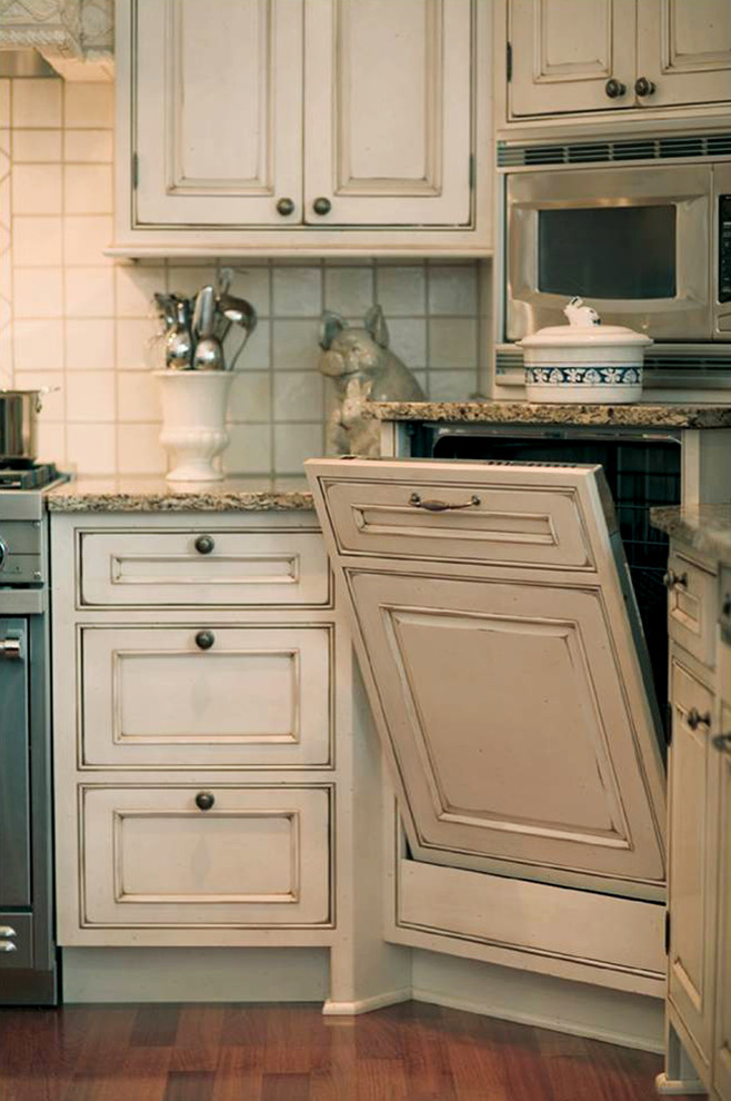 Large cottage l-shaped medium tone wood floor eat-in kitchen photo in Detroit with raised-panel cabinets, distressed cabinets, paneled appliances, beige walls, an island, a drop-in sink, granite countertops, white backsplash and ceramic backsplash