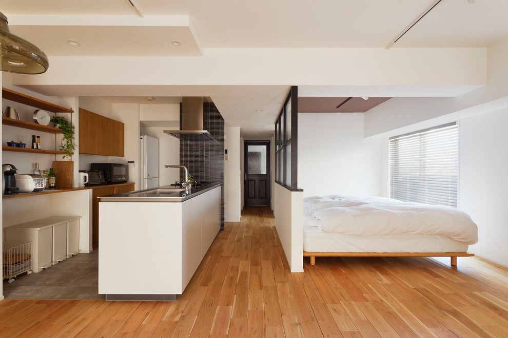 モダンスタイルのおしゃれな寝室 (白い壁、無垢フローリング、茶色い床) のインテリア