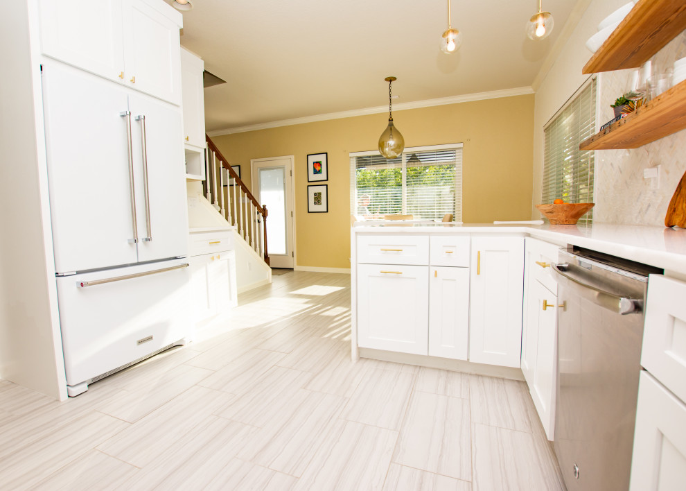 Example of a transitional porcelain tile and gray floor eat-in kitchen design in Austin with an undermount sink, shaker cabinets, white cabinets, quartz countertops, white backsplash, marble backsplash, stainless steel appliances, a peninsula and white countertops
