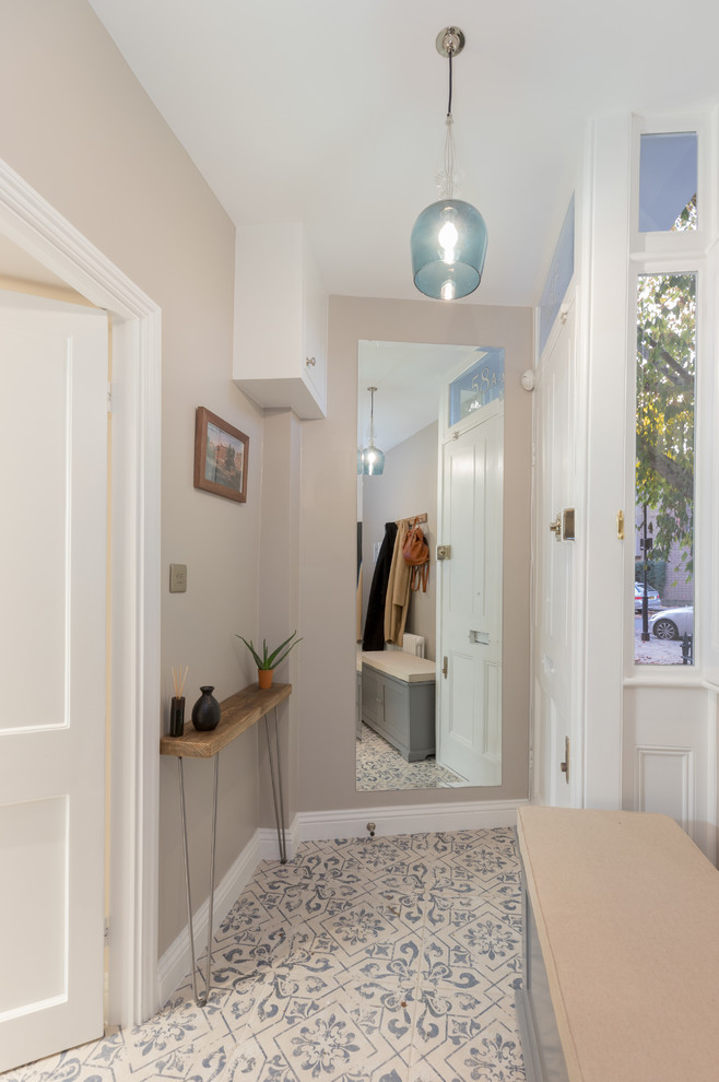 Photo of a small modern hallway in London with beige walls, ceramic floors and beige floor.