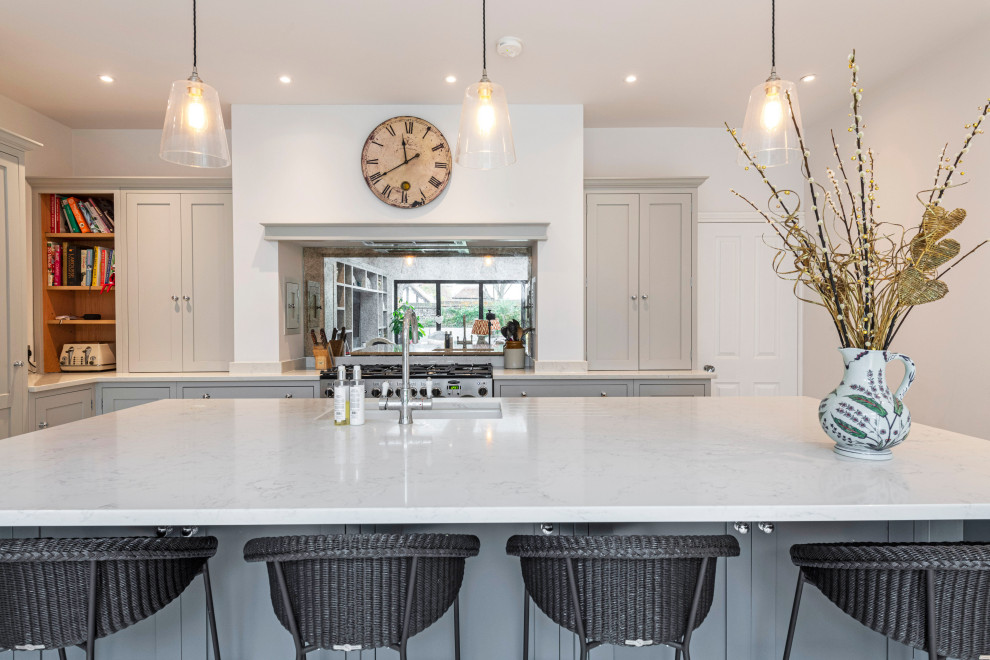 Inspiration for an expansive traditional l-shaped open plan kitchen in Dorset with an undermount sink, shaker cabinets, grey cabinets, quartzite benchtops, stainless steel appliances, with island and white benchtop.
