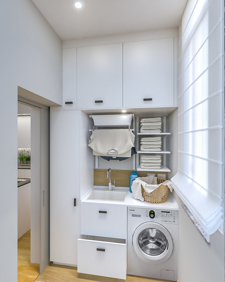 Photo of a small contemporary single-wall dedicated laundry room in Milan with a single-bowl sink, flat-panel cabinets, white cabinets, laminate benchtops, grey walls, porcelain floors, an integrated washer and dryer and white benchtop.