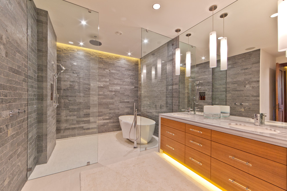 This is an example of a contemporary bathroom in San Francisco with a freestanding tub and grey benchtops.