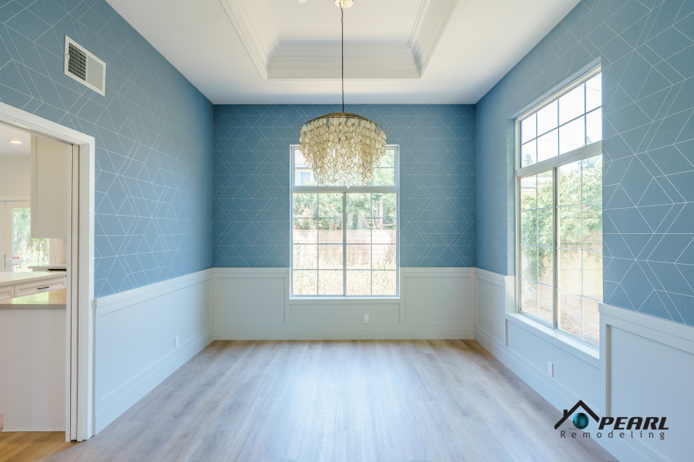 Réalisation d'une grande salle à manger minimaliste fermée avec un mur bleu, parquet clair, un sol beige, un plafond voûté et du papier peint.