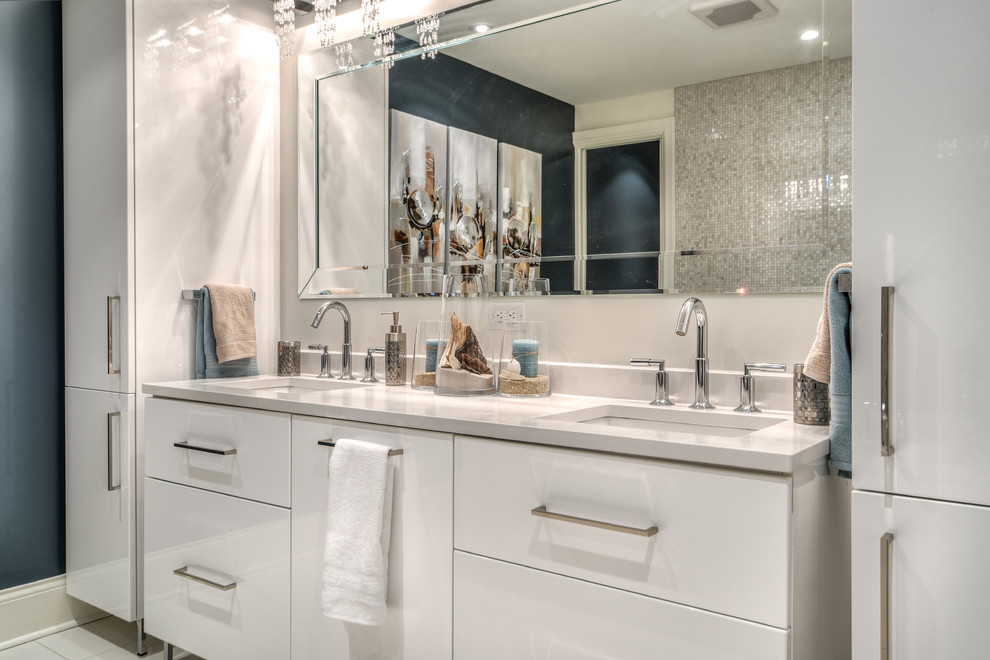 Design ideas for a mid-sized contemporary master bathroom in Montreal with flat-panel cabinets, white cabinets, a two-piece toilet, gray tile, glass sheet wall, blue walls, an undermount sink, marble benchtops and a hinged shower door.