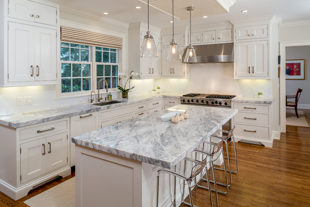 Eat-in kitchen - large transitional l-shaped medium tone wood floor and brown floor eat-in kitchen idea in New York with an undermount sink, white cabinets, quartzite countertops, white backsplash, subway tile backsplash, stainless steel appliances, an island and beaded inset cabinets