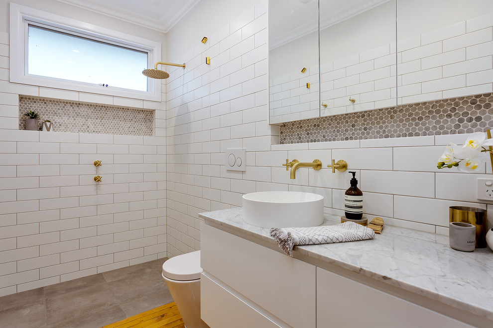 Inspiration for a contemporary bathroom in Other with flat-panel cabinets, white cabinets, a curbless shower, a wall-mount toilet, brown tile, white tile, white walls, a vessel sink, grey floor, an open shower and white benchtops.