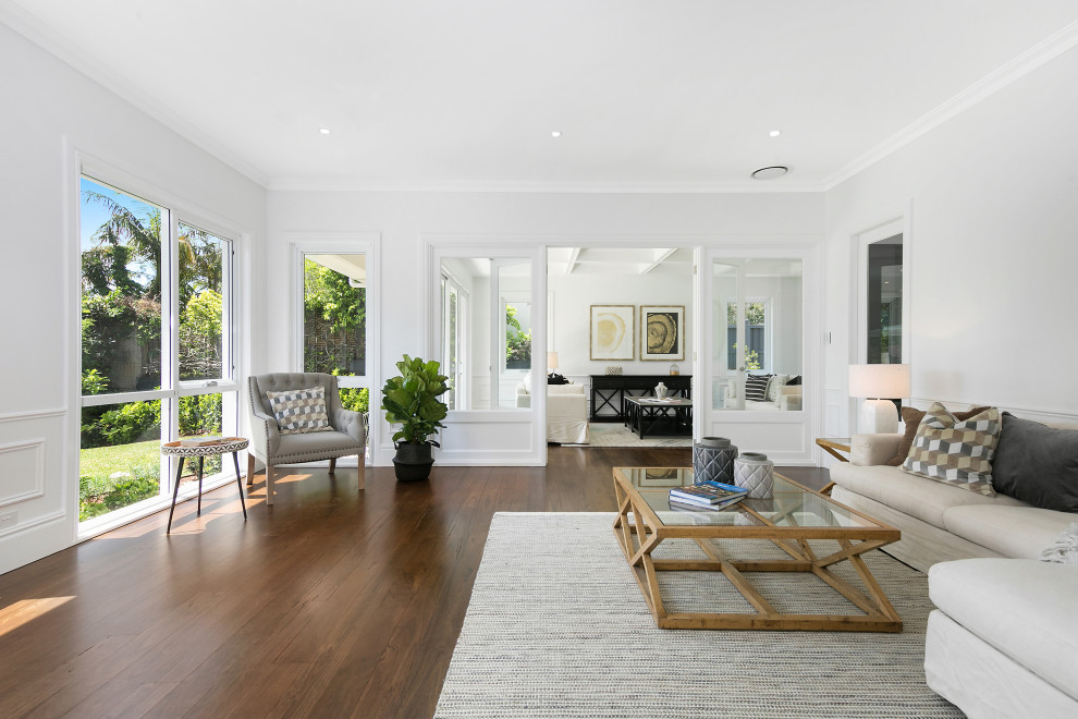 Large contemporary formal open concept living room in Sydney with white walls, a freestanding tv and dark hardwood floors.
