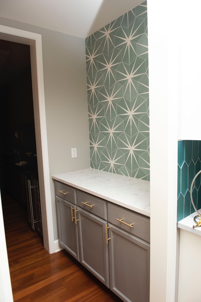 Inspiration for a small midcentury galley wet bar in Seattle with shaker cabinets, grey cabinets, quartzite benchtops, green splashback, cement tile splashback, medium hardwood floors and white benchtop.