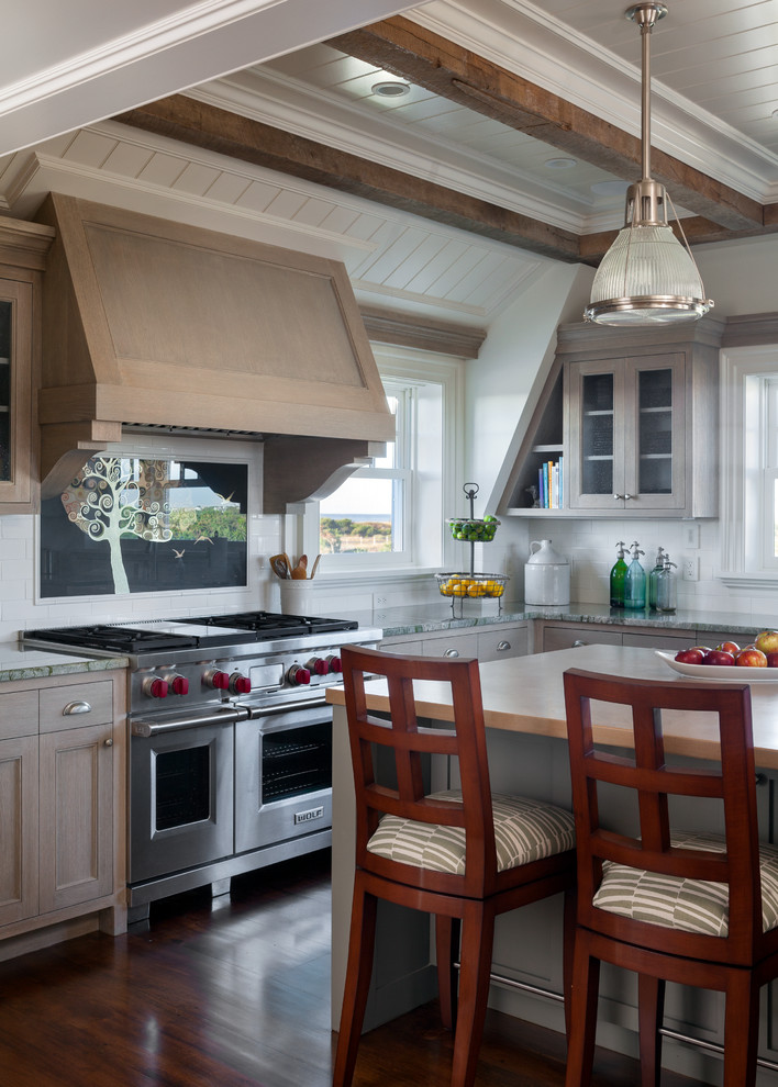 Photo of a mid-sized beach style u-shaped open plan kitchen in Boston with beaded inset cabinets, light wood cabinets, white splashback, stainless steel appliances, a farmhouse sink, granite benchtops, subway tile splashback, dark hardwood floors and with island.