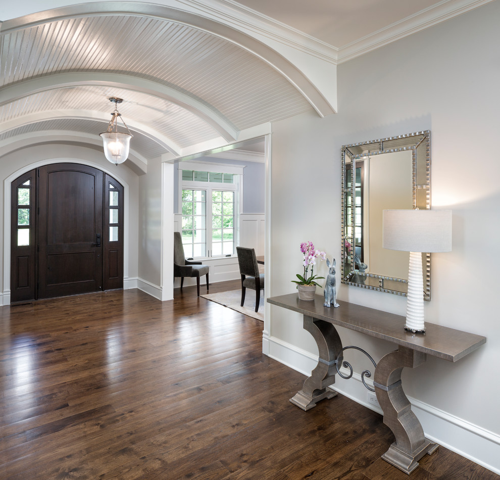 Example of a transitional medium tone wood floor single front door design in Chicago with a dark wood front door