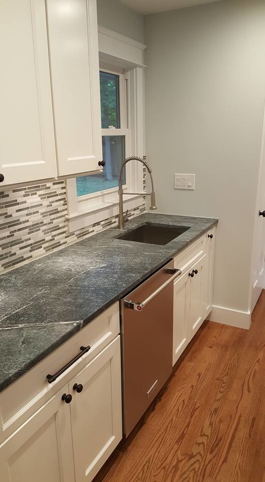 Large transitional l-shaped medium tone wood floor open concept kitchen photo in Baltimore with shaker cabinets, white cabinets, an island, soapstone countertops, multicolored backsplash, matchstick tile backsplash and stainless steel appliances