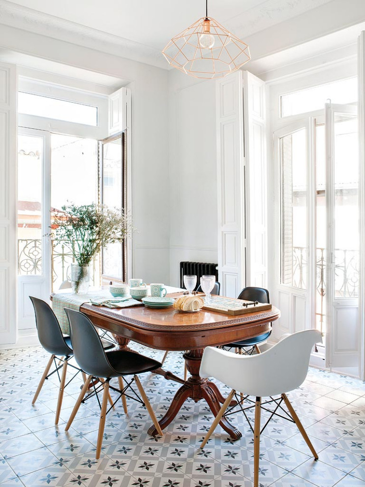 Design ideas for a mid-sized contemporary open plan dining in Madrid with white walls, multi-coloured floor, panelled walls, ceramic floors, a standard fireplace and a metal fireplace surround.