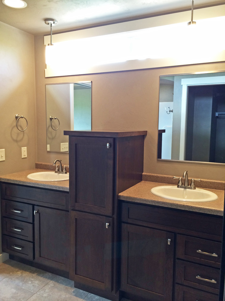 Photo of a mid-sized arts and crafts master bathroom in Milwaukee with a drop-in sink, shaker cabinets, dark wood cabinets, laminate benchtops and beige walls.