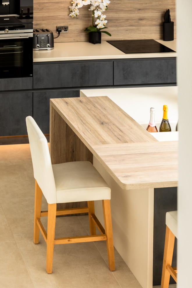This is an example of a large contemporary single-wall eat-in kitchen in Other with an integrated sink, flat-panel cabinets, grey cabinets, solid surface benchtops, timber splashback, panelled appliances, with island and beige benchtop.