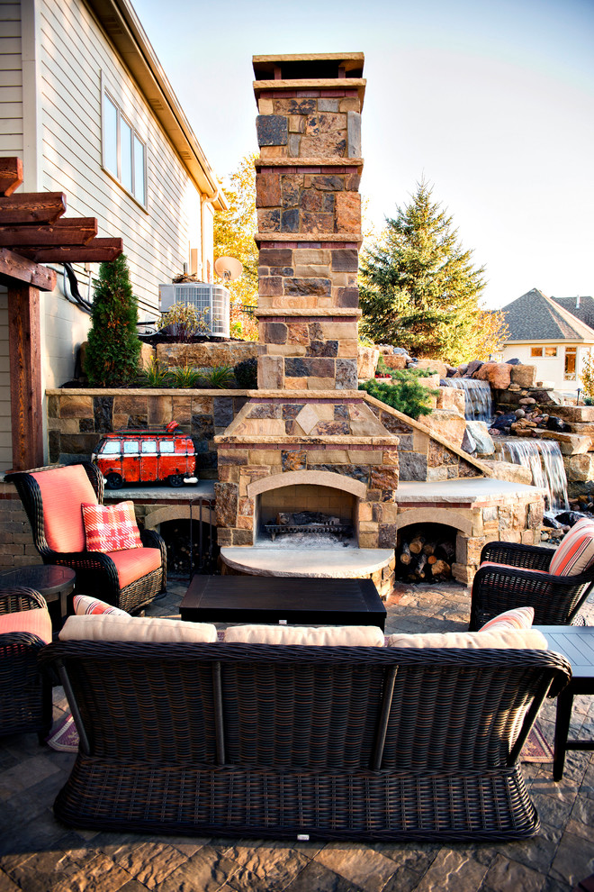 Photo of a large country backyard patio in Minneapolis with a fire feature and no cover.