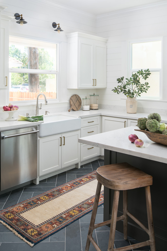 Mid-sized ornate l-shaped slate floor and gray floor kitchen photo in Sacramento with a farmhouse sink, shaker cabinets, white cabinets, quartzite countertops, stone slab backsplash, stainless steel appliances and an island