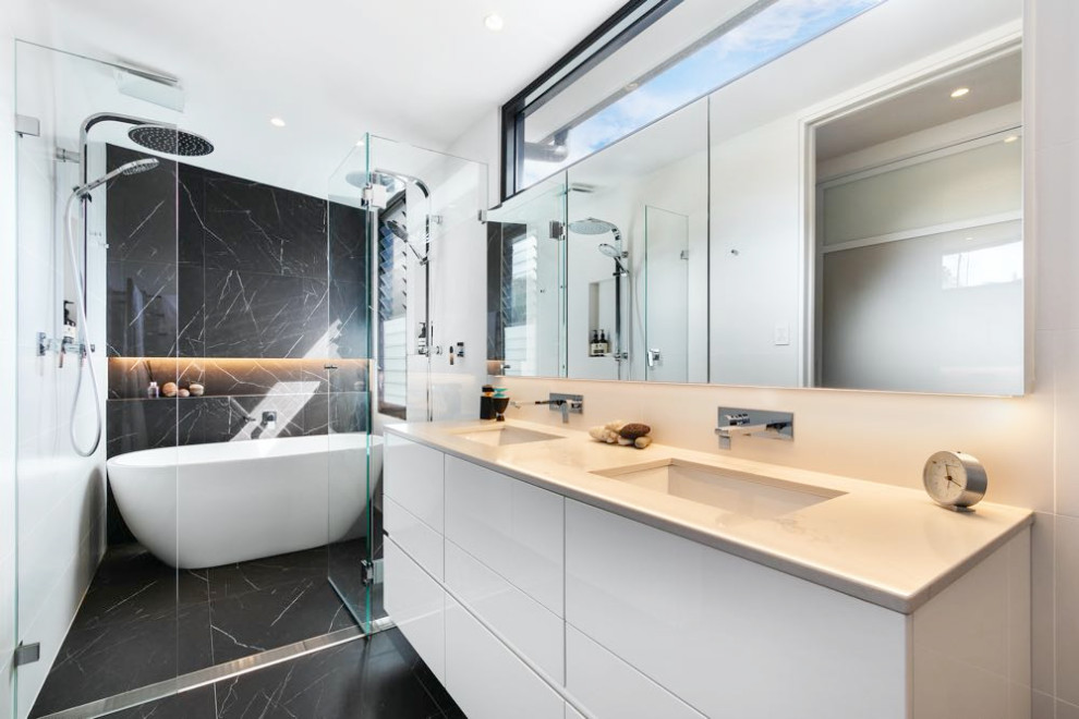 Design ideas for a small modern master bathroom in Sydney with beaded inset cabinets, white cabinets, a freestanding tub, an alcove shower, a one-piece toilet, black tile, pebble tile, black walls, ceramic floors, an undermount sink, laminate benchtops, black floor, a hinged shower door, white benchtops, a double vanity and a floating vanity.