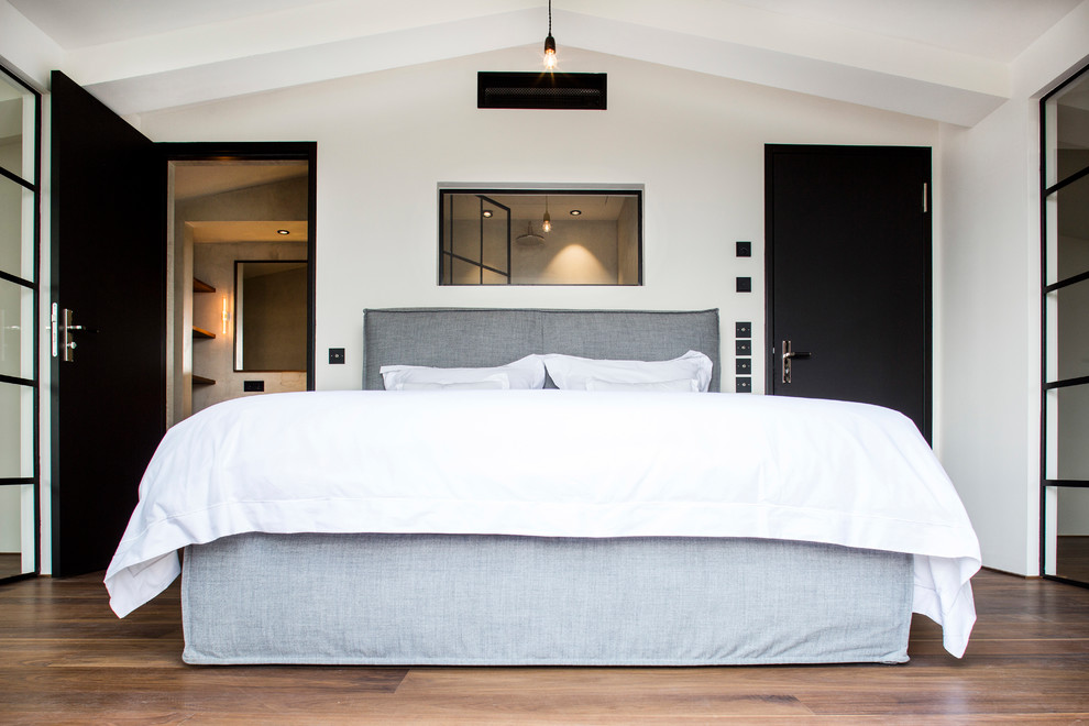 Hauptschlafzimmer ohne Kamin mit weißer Wandfarbe, braunem Holzboden und braunem Boden in Berlin