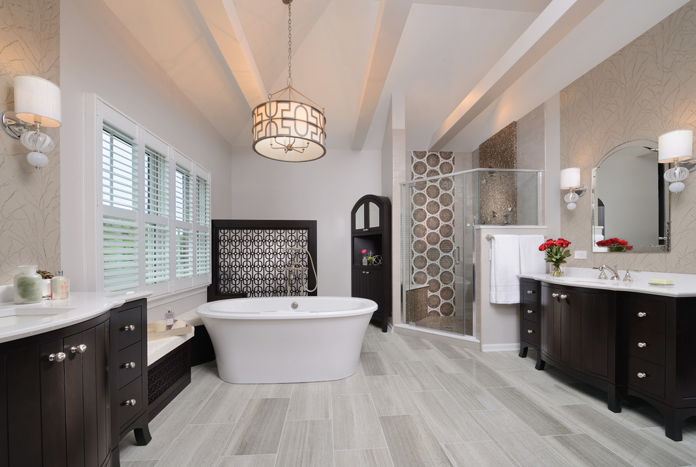 Large transitional master brown tile and stone tile marble floor freestanding bathtub photo with furniture-like cabinets, dark wood cabinets, an undermount sink, quartz countertops, a two-piece toilet and multicolored walls