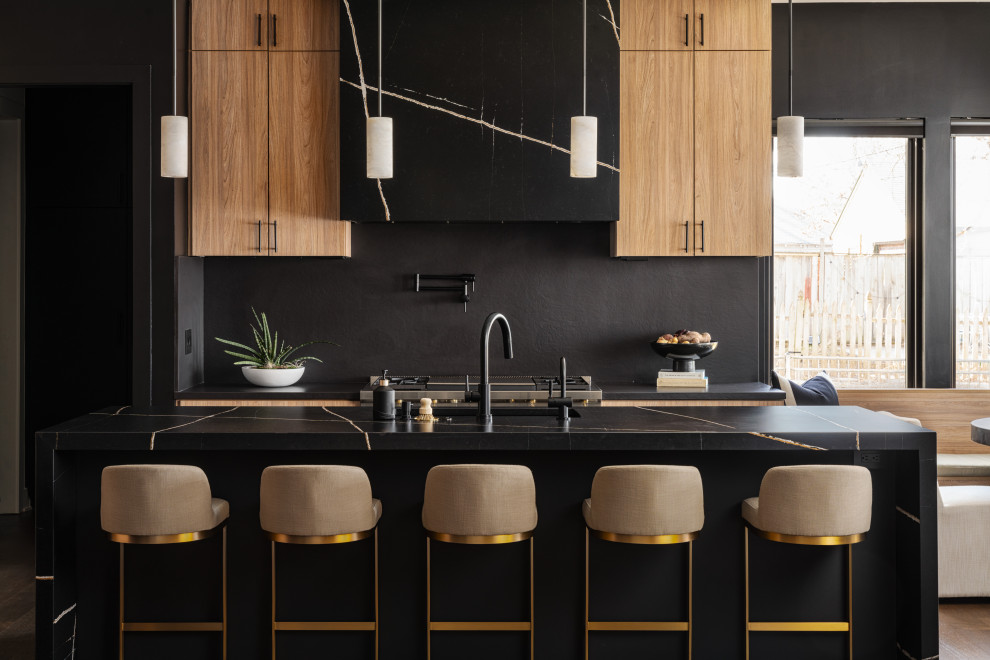 Inredning av ett modernt mellanstort svart svart kök, med en undermonterad diskho, släta luckor, skåp i ljust trä, bänkskiva i koppar, svart stänkskydd, stänkskydd i sten, integrerade vitvaror, mellanmörkt trägolv, en köksö och brunt golv