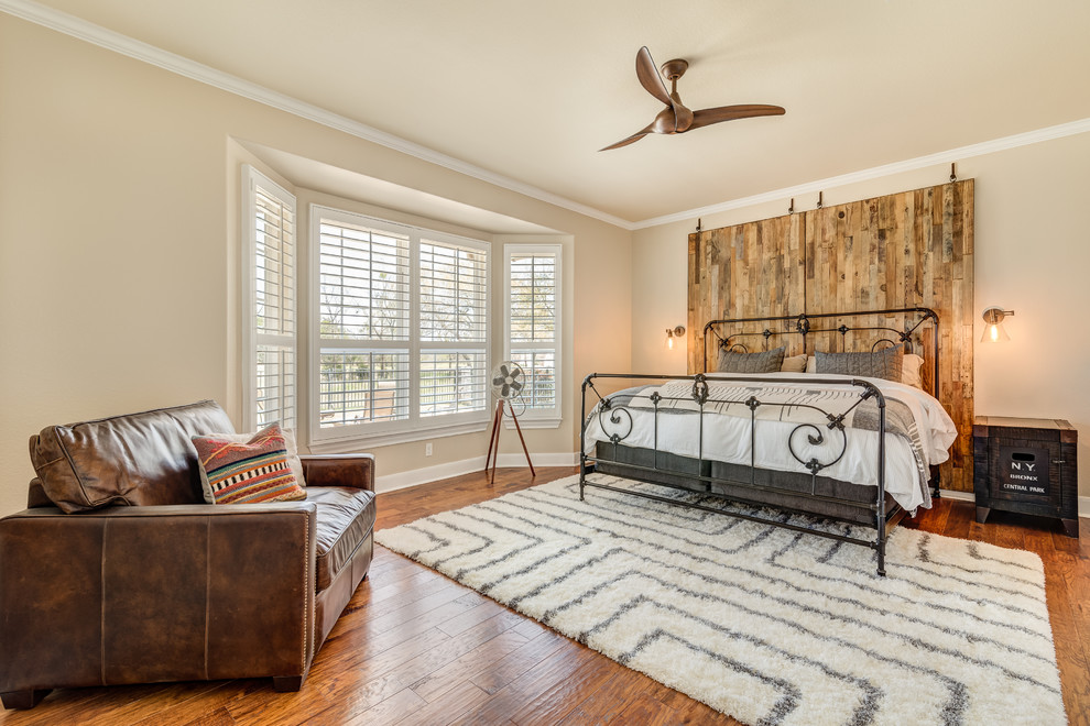 Inspiration for a country master bedroom in Austin with beige walls and dark hardwood floors.